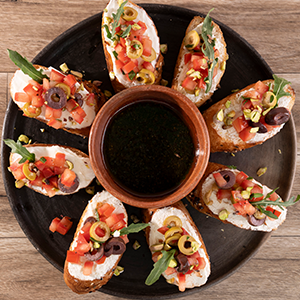 Tapas con baguette, queso de cabra y topping provenzal